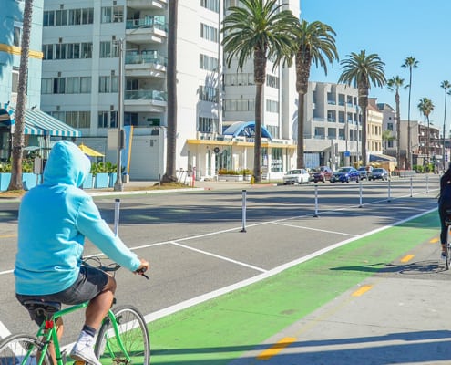 Two people biking in Ocean Ave bikeway (2000x600)