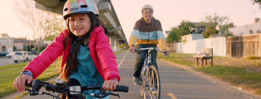 Girl with father under BART tracks Ohlone Greenway Bikeway