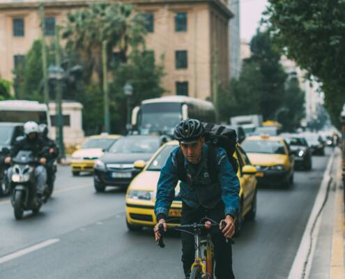 Bike commuter on side of road without a bike lane.