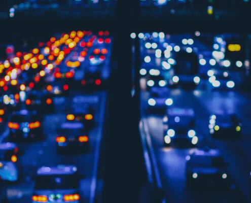 Misery depicted in blurry traffic lights on a crowded rush hour freeway.