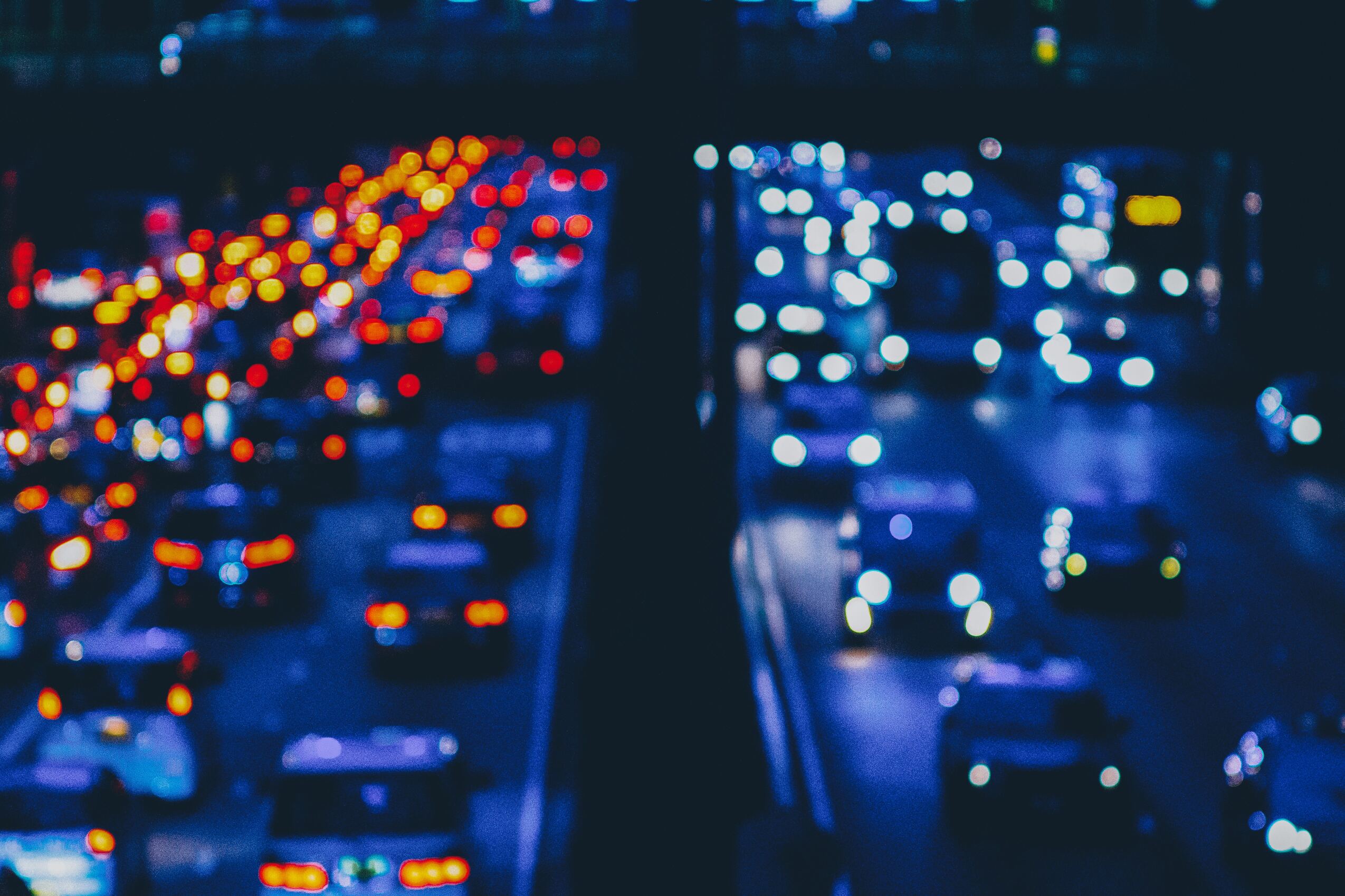 Misery depicted in blurry traffic lights on a crowded rush hour freeway.
