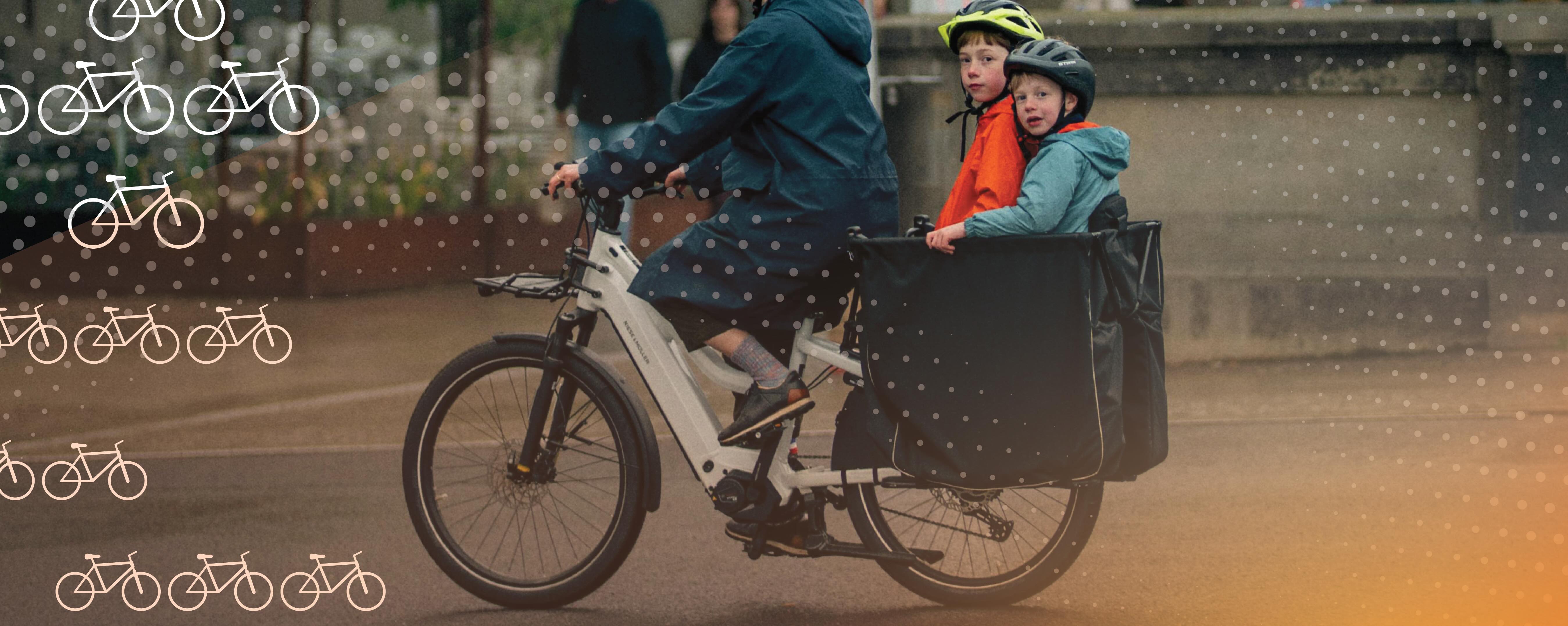 Adult riding a white cargo bike with two helmeted children seated in the front box on a city street. A dotted graphic overlay and white bicycle icons appear across the image, with a warm light flare in the lower right corner.
