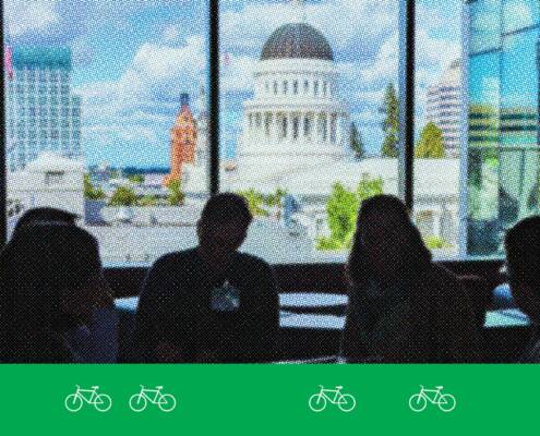 Advocates sit in silhouette inside the California State Capitol, facing a bright window with a view of Sacramento’s Capitol dome and downtown buildings. A green graphic band with white bicycle icons runs along the bottom of the image.